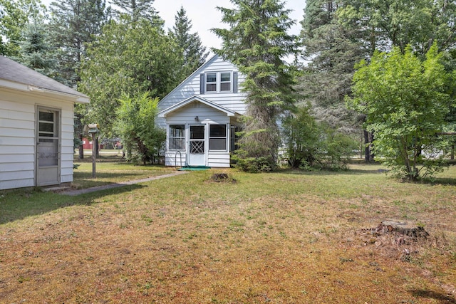 425 6th St, Baldwin, MI 49304 - view of green lawn featuring a sunroom