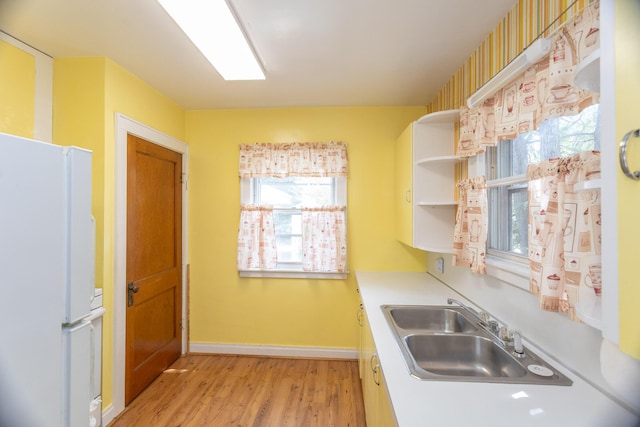 425 6th St, Baldwin, MI 49304 - kitchen with freestanding refrigerator, light wood-style flooring, open shelves, and light countertops