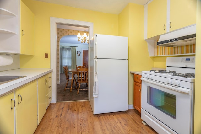 425 6th St, Baldwin, MI 49304 - kitchen featuring white appliances, under cabinet range hood, open shelves, light countertops, and a chandelier
