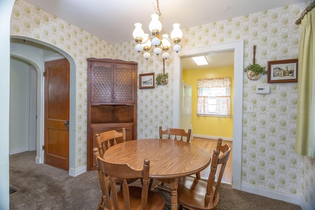 425 6th St, Baldwin, MI 49304 - carpeted dining space featuring a chandelier and arched walkways