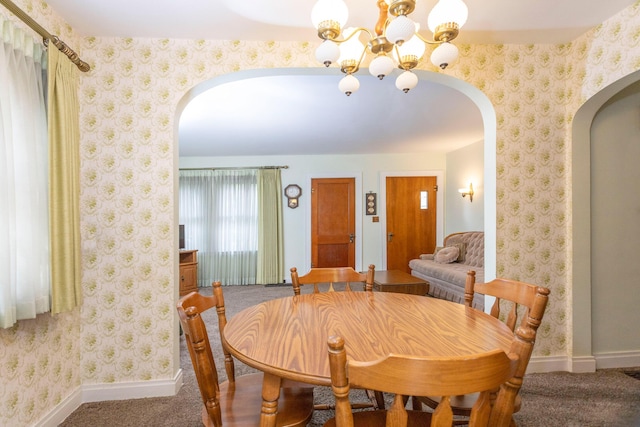 425 6th St, Baldwin, MI 49304 - carpeted dining space with arched walkways, a chandelier, and wallpapered walls