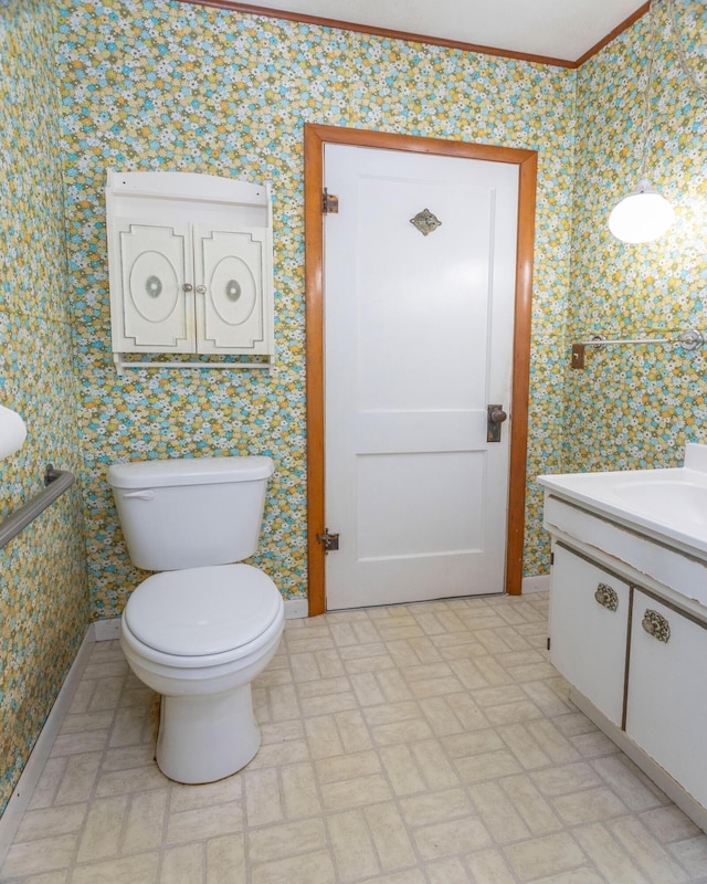 425 6th St, Baldwin, MI 49304 - bathroom with wallpapered walls, vanity, brick patterned floors, and ornamental molding