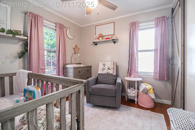32247 Annapolis St, Wayne, MI 48184 - bedroom with a nursery area, light wood-style flooring, crown molding, and a ceiling fan