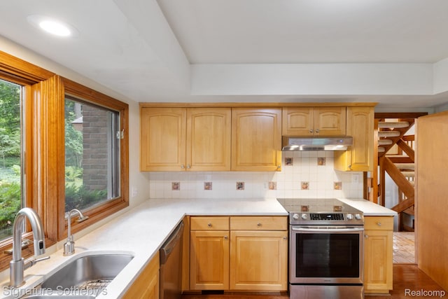 26311 W 14 Mile Rd, Franklin, MI 48025 - kitchen with stainless steel appliances, under cabinet range hood, backsplash, light brown cabinetry, and light countertops