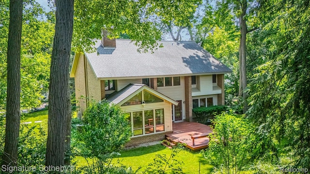 26311 W 14 Mile Rd, Franklin, MI 48025 - back of property with a chimney, a wooden deck, roof with shingles, and a yard