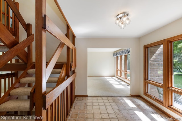 26311 W 14 Mile Rd, Franklin, MI 48025 - hall with stairway, light carpet, and a chandelier