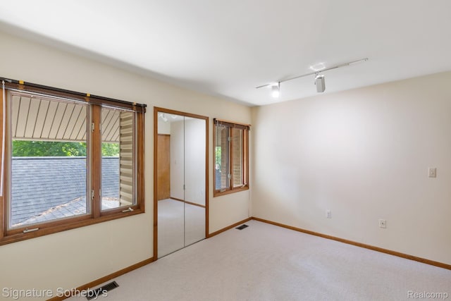 26311 W 14 Mile Rd, Franklin, MI 48025 - empty room with healthy amount of natural light, light colored carpet, and track lighting