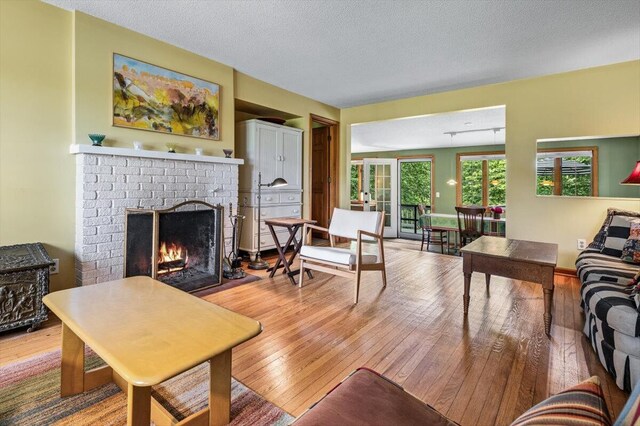 5515 Kaiser Rd, Sawyer, MI 49125 - living room with light wood finished floors, a brick fireplace, and a textured ceiling