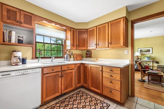 5515 Kaiser Rd, Sawyer, MI 49125 - kitchen with white dishwasher, light countertops, light tile patterned floors, and brown cabinetry