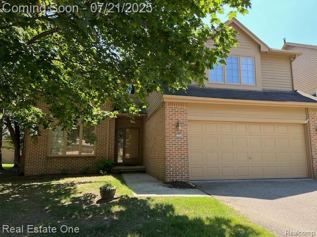6630 Heron Pt, West Bloomfield, MI 48323 - view of front of property with brick siding, driveway, and an attached garage