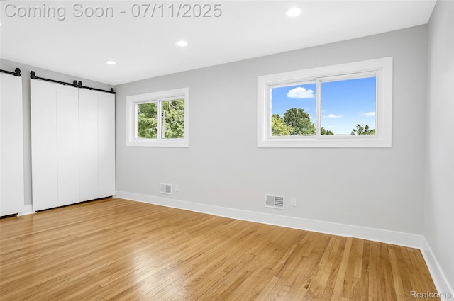22222 Evergreen St, Macomb, MI 48082 - unfurnished bedroom with light wood finished floors, a barn door, and recessed lighting