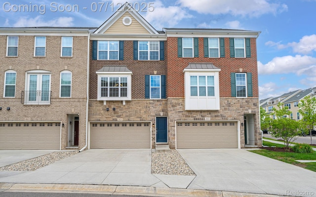2825 Ridington Rd, Ann Arbor, MI 48105 - townhome / multi-family property featuring an attached garage, concrete driveway, and stone siding