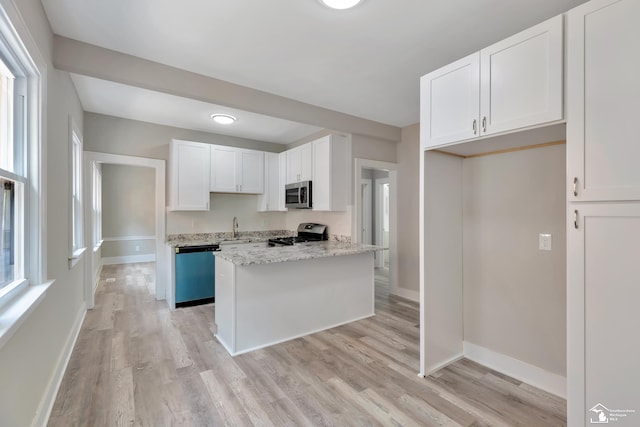 2651 Lakewood St, Detroit, MI 48215 - kitchen with stainless steel microwave, dishwasher, gas range oven, light wood-style floors, and white cabinets