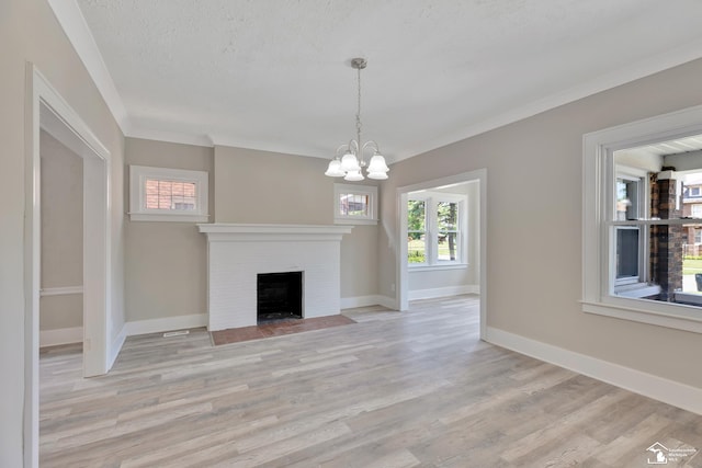 2651 Lakewood St, Detroit, MI 48215 - unfurnished living room featuring light wood-style floors, a chandelier, a fireplace, crown molding, and a textured ceiling