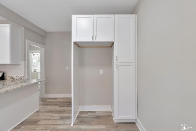 2651 Lakewood St, Detroit, MI 48215 - kitchen featuring white cabinets, light wood finished floors, and light stone countertops