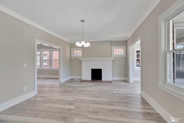 2651 Lakewood St, Detroit, MI 48215 - unfurnished living room featuring a chandelier, light wood finished floors, a fireplace, and ornamental molding