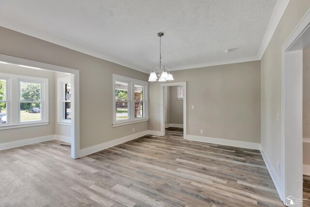 2651 Lakewood St, Detroit, MI 48215 - unfurnished dining area with a chandelier, light wood-style flooring, ornamental molding, and a textured ceiling