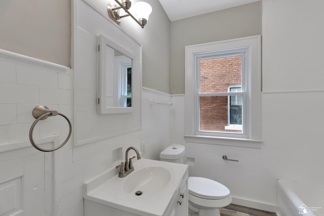 2651 Lakewood St, Detroit, MI 48215 - bathroom featuring vanity, tile walls, a tub to relax in, and wood finished floors