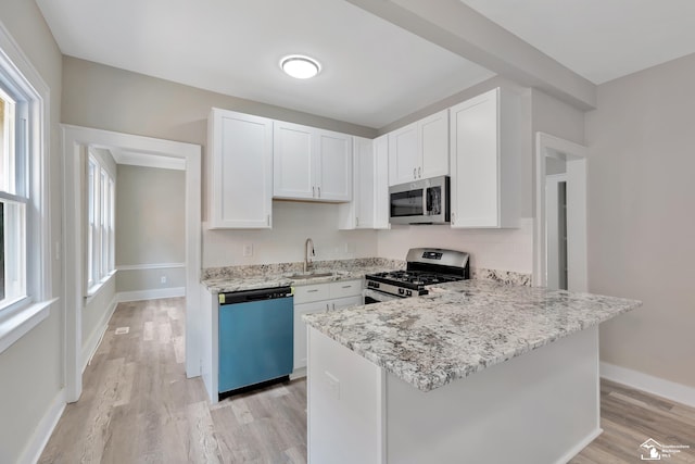 2651 Lakewood St, Detroit, MI 48215 - kitchen featuring stainless steel appliances, healthy amount of natural light, light wood-style flooring, and white cabinets
