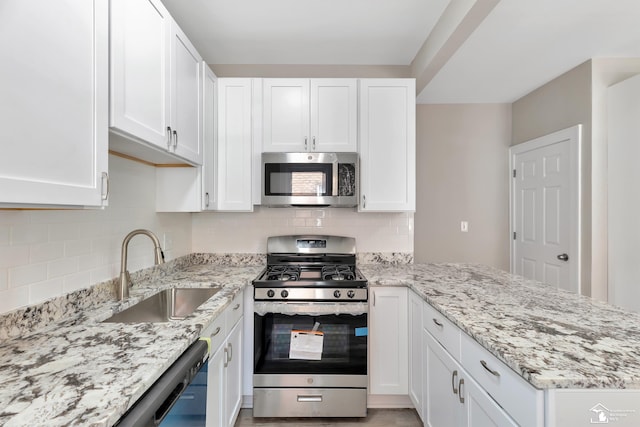 2651 Lakewood St, Detroit, MI 48215 - kitchen featuring appliances with stainless steel finishes, white cabinets, and a peninsula