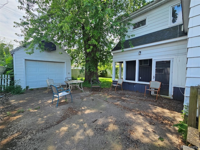 607 Roome Ct, Flint, MI 48503 - view of patio with a garage, an outbuilding, and driveway