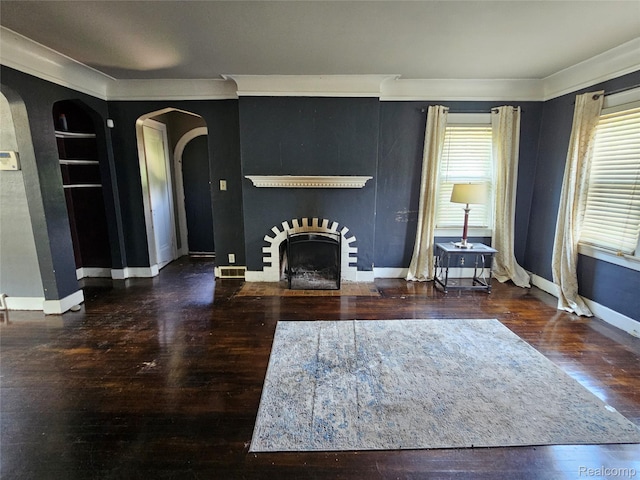 607 Roome Ct, Flint, MI 48503 - living room featuring arched walkways, wood finished floors, crown molding, a fireplace with flush hearth, and built in features