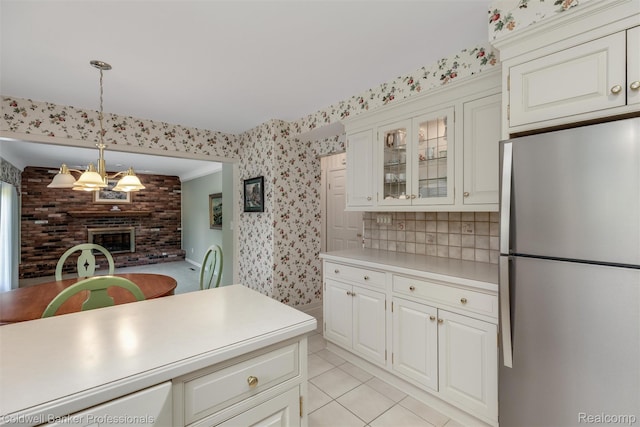 21600 Eastbrook Ct, Grosse Pointe Woods, MI 48236 - kitchen with freestanding refrigerator, light countertops, wallpapered walls, glass insert cabinets, and hanging light fixtures