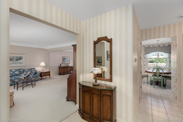 21600 Eastbrook Ct, Grosse Pointe Woods, MI 48236 - hallway with a chandelier, light tile patterned floors, wallpapered walls, and light colored carpet