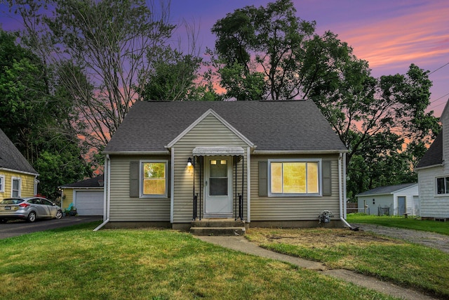 932 Parker Ave, Kalamazoo, MI 49008 - view of front facade with entry steps, a detached garage, a yard, and a shingled roof