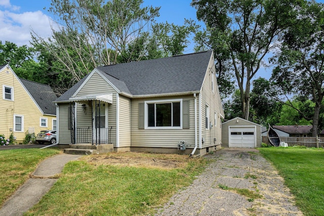 932 Parker Ave, Kalamazoo, MI 49008 - view of front of house with asphalt driveway, a front yard, an outdoor structure, a shingled roof, and a garage