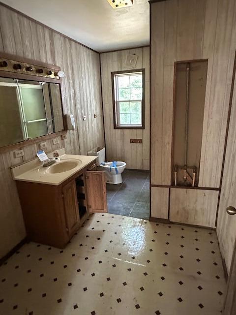 1675 E 8th St, White Cloud, MI 49349 - bathroom with tile patterned floors, vanity, and wood walls