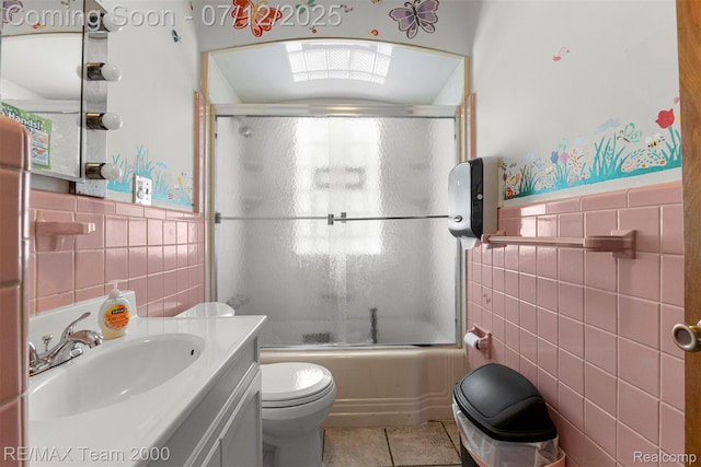 27055 Ann Arbor Trl, Dearborn Heights, MI 48127 - full bathroom with tile walls, tile patterned flooring, vanity, bath / shower combo with glass door, and wainscoting