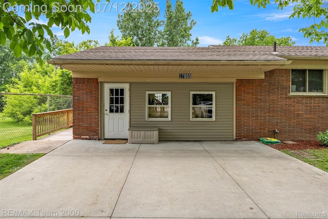 27055 Ann Arbor Trl, Dearborn Heights, MI 48127 - property entrance featuring brick siding, a patio area, and a shingled roof