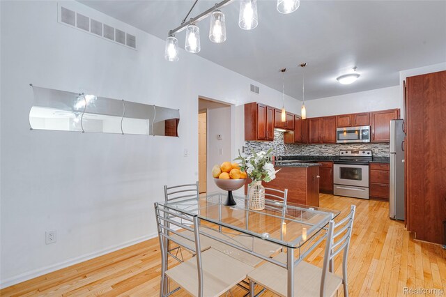 41666 Tera Ln, Novi, MI 48375 - kitchen featuring stainless steel appliances, light wood-style flooring, dark countertops, decorative backsplash, and pendant lighting