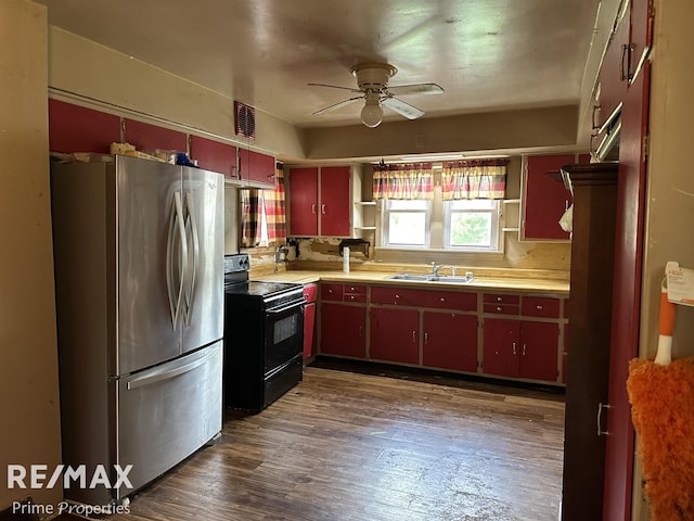1615 Pound Dr, Flint, MI 48532 - kitchen featuring freestanding refrigerator, black electric range, red cabinets, ceiling fan, and dark wood-style flooring