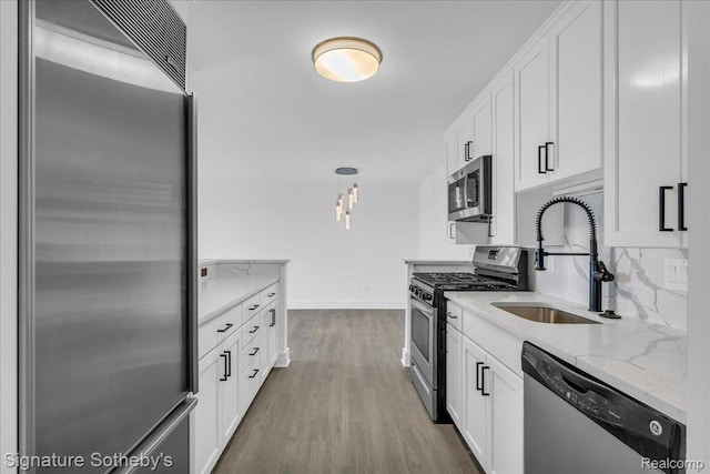 411 S Old Woodward Ave Unit 924, Birmingham, MI 48009 - kitchen with appliances with stainless steel finishes, white cabinets, wood finished floors, and light stone countertops