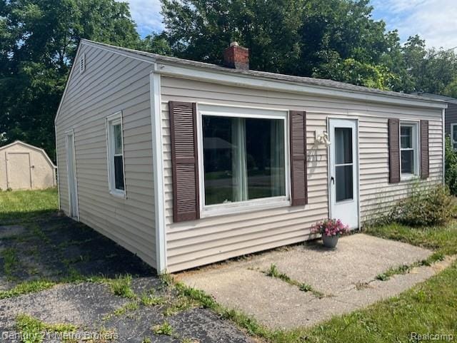 2117 E Buder Ave, Flint, MI 48529 - view of front of property featuring a chimney and a storage unit