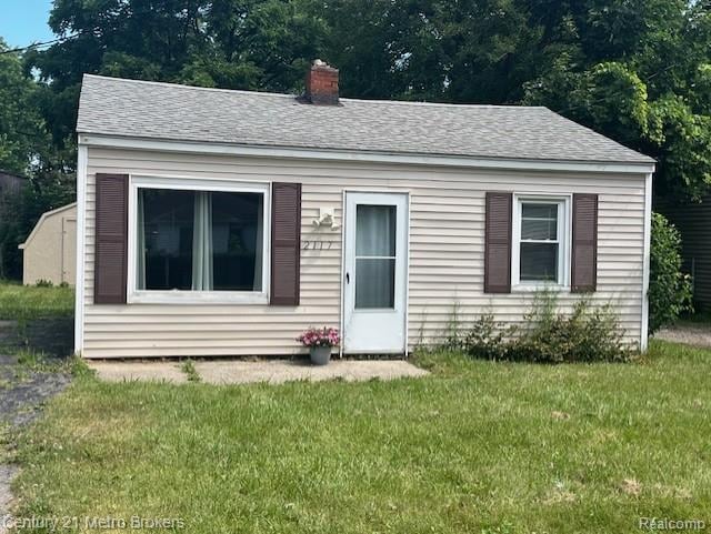 2117 E Buder Ave, Flint, MI 48529 - bungalow-style home featuring a front yard, a chimney, and roof with shingles