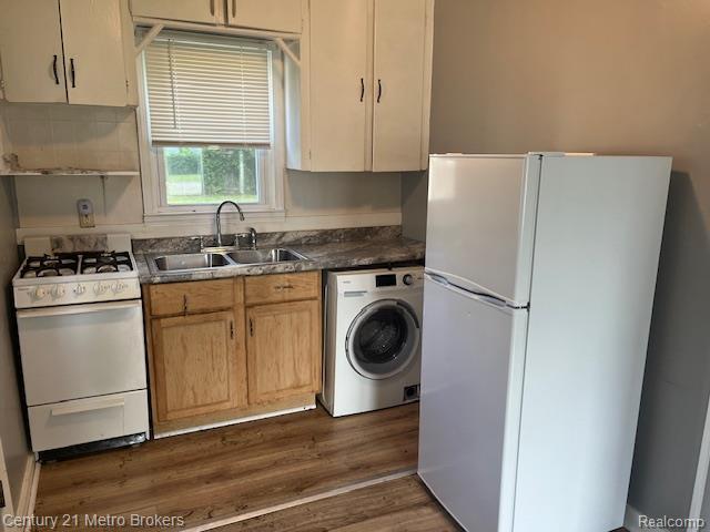 2117 E Buder Ave, Flint, MI 48529 - kitchen featuring white appliances, washer / clothes dryer, dark wood-style floors, and dark countertops