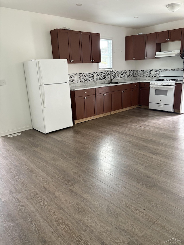 2024 Cooper Ave, Saginaw, MI 48602 - kitchen with white appliances, dark wood-style floors, under cabinet range hood, light countertops, and dark brown cabinets