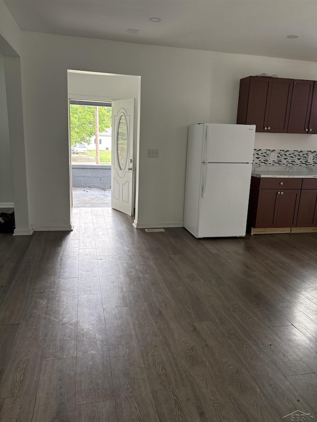 2024 Cooper Ave, Saginaw, MI 48602 - kitchen featuring freestanding refrigerator, dark wood finished floors, light countertops, decorative backsplash, and dark brown cabinets