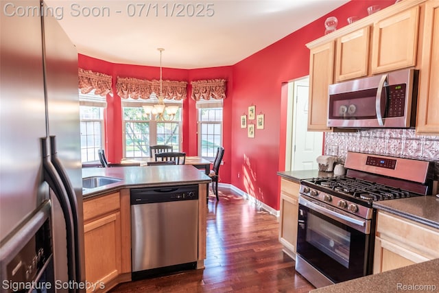 49866 Sleeping River Dr, Macomb, MI 48042 - kitchen with appliances with stainless steel finishes, dark countertops, light brown cabinetry, and plenty of natural light