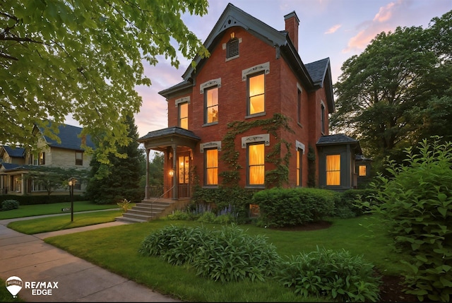 616 S Warren Ave, Saginaw, MI 48607 - victorian-style house with a chimney, a lawn, and brick siding