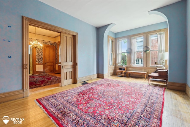 616 S Warren Ave, Saginaw, MI 48607 - living area with a chandelier, wood finished floors, and arched walkways