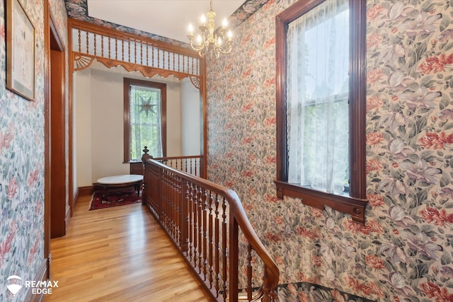 616 S Warren Ave, Saginaw, MI 48607 - hall with wallpapered walls, an upstairs landing, light wood-style flooring, and a chandelier