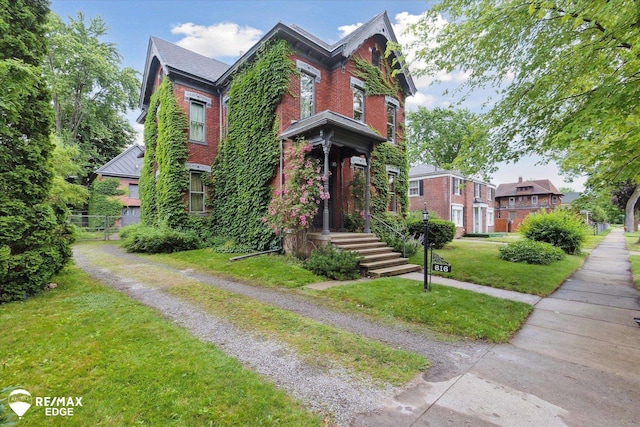 616 S Warren Ave, Saginaw, MI 48607 - victorian house with a front yard and brick siding