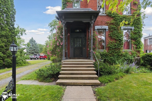 616 S Warren Ave, Saginaw, MI 48607 - doorway to property featuring brick siding and a lawn