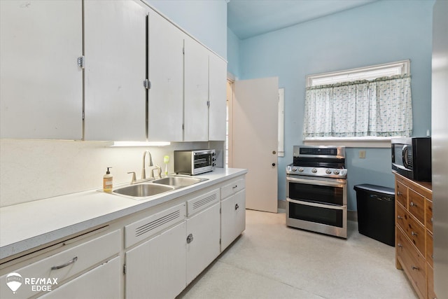 616 S Warren Ave, Saginaw, MI 48607 - kitchen with double oven range, white cabinetry, and light countertops