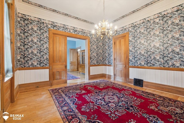 616 S Warren Ave, Saginaw, MI 48607 - dining area featuring wallpapered walls, a wainscoted wall, a chandelier, and light wood-style floors