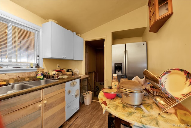 3875 Sobieski St, Hamtramck, MI 48212 - kitchen featuring stainless steel fridge, vaulted ceiling, wood finished floors, white cabinets, and dark countertops